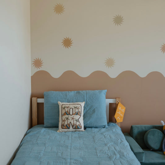 Kids bedroom with wavy wallpaper and warm sun decals